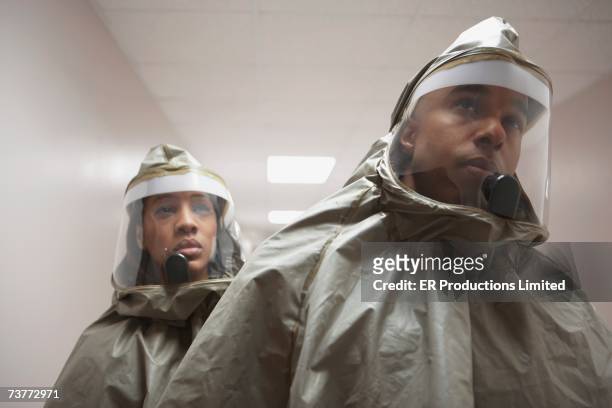 African man and woman in hazmat suits