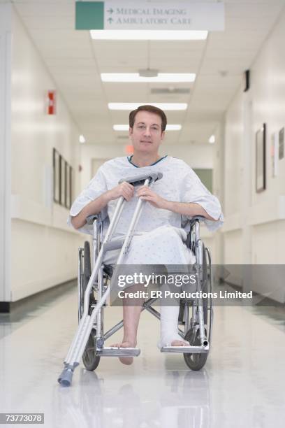 man with broken leg in wheelchair at hospital - broken leg stock pictures, royalty-free photos & images