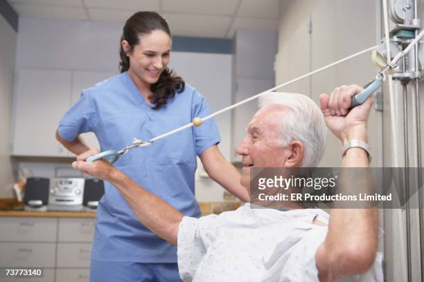 senior male patient performing physical therapy with nurse - motion sickness stock pictures, royalty-free photos & images
