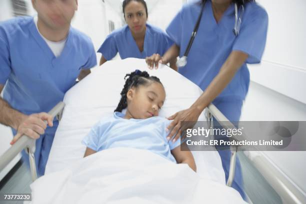doctors wheeling african girl in gurney - coma stock pictures, royalty-free photos & images
