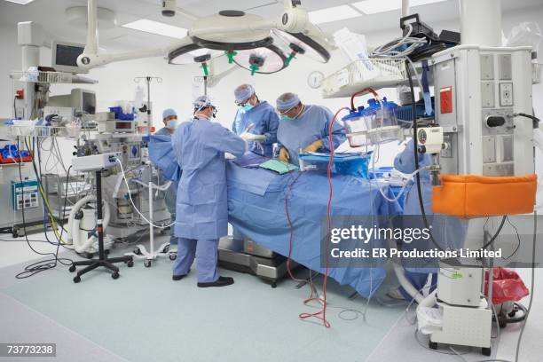 surgeons performing surgery in operating room - operating room fotografías e imágenes de stock