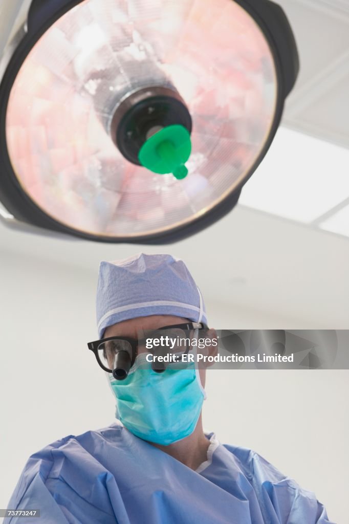 Surgeon wearing binocular loupes in operating room