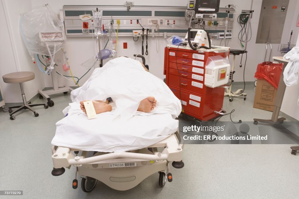 Deceased patient under sheet with toe tag in emergency room