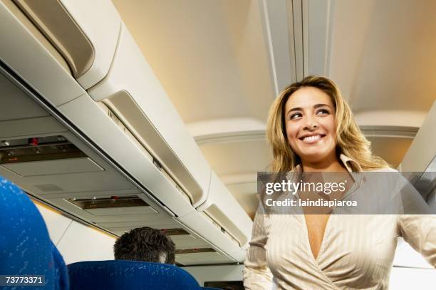 low angle view of woman in aisle of airplane - decolleté stockfoto's en -beelden
