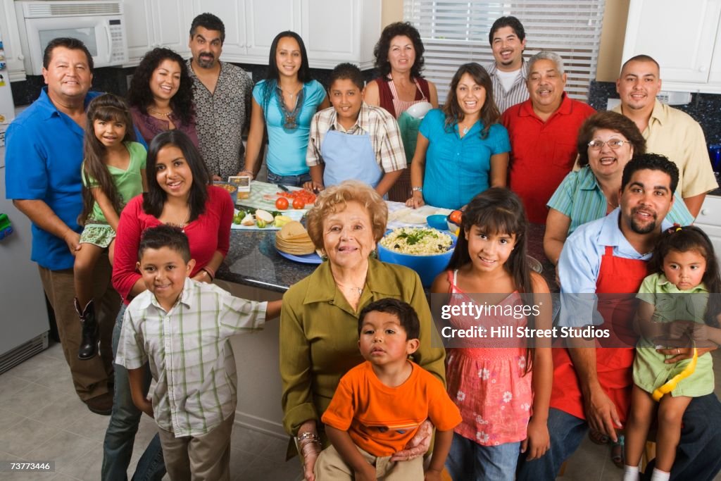 Large Hispanic family in kitchen with food