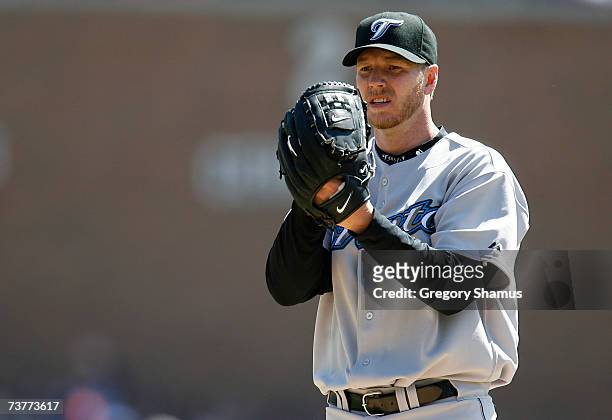 Starting pitcher Roy Halladay of the Toronto Blue Jays looks towards the catcher for a sign as he gets set to throw a pitch against the Detroit...