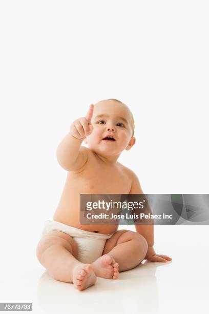 studio shot of baby pointing - baby pointing stockfoto's en -beelden