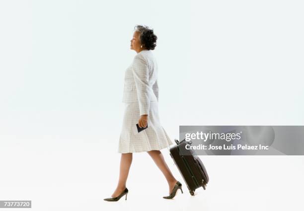 african businesswoman pulling suitcase - person walking side stock pictures, royalty-free photos & images