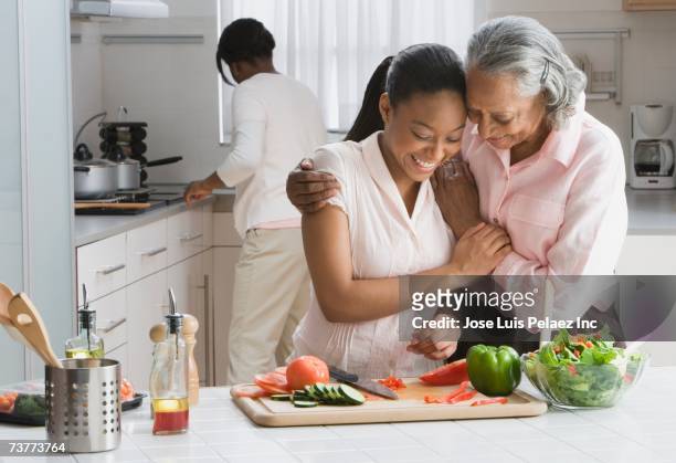 african grandmother and granddaughter preparing food in kitchen - 3 women senior kitchen stock pictures, royalty-free photos & images