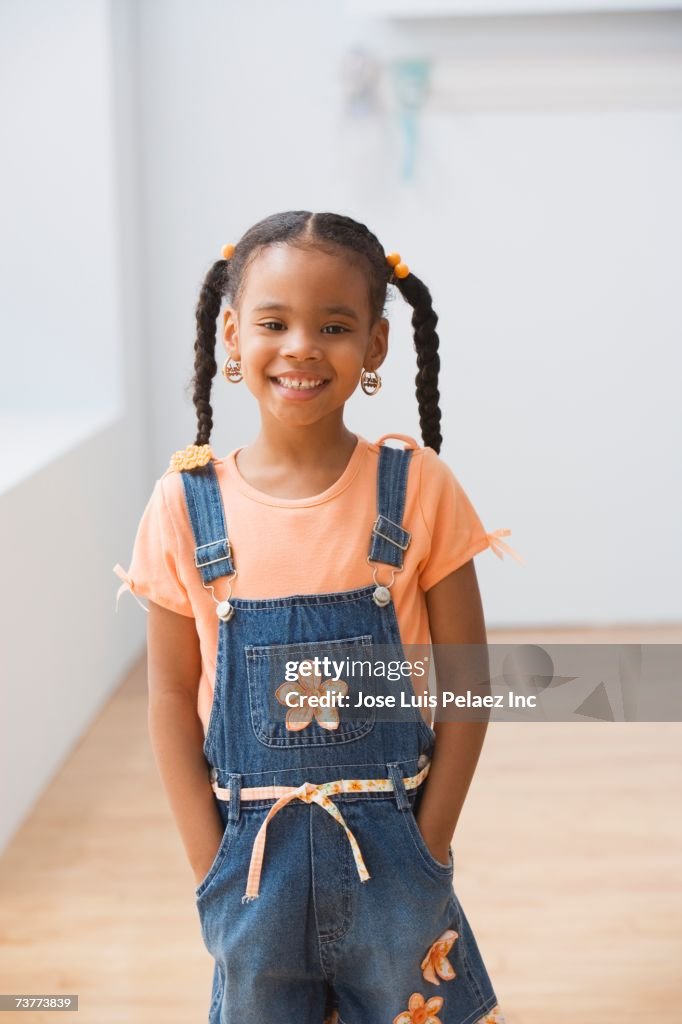 African girl standing with hands in pockets