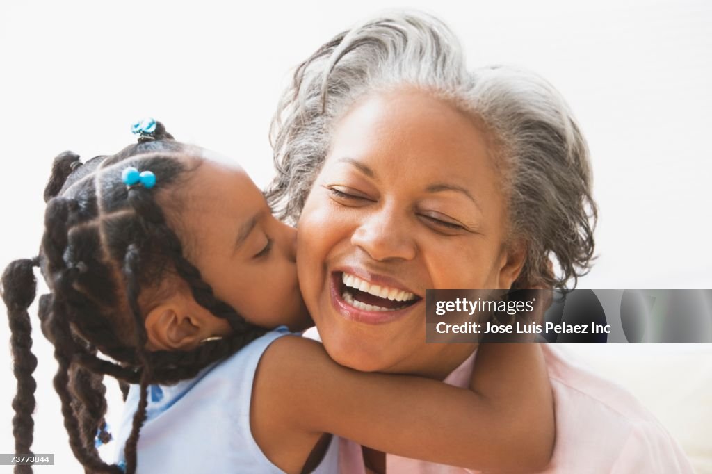African grandmother and granddaughter hugging