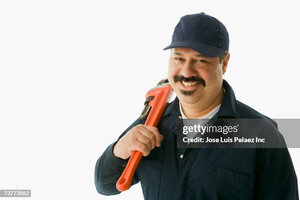 studio shot of hispanic handyman with wrench - handyman smiling stock pictures, royalty-free photos & images