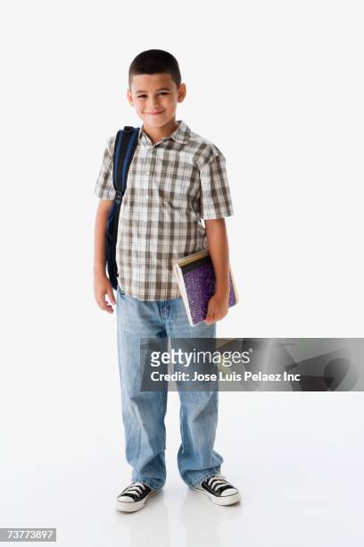 studio shot of hispanic boy carrying backpack and books - school boy with bag stockfoto's en -beelden