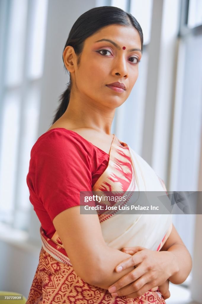 Indian woman in traditional clothing standing with arms crossed