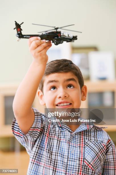 hispanic boy playing with toy helicopter - toy helicopter stock pictures, royalty-free photos & images