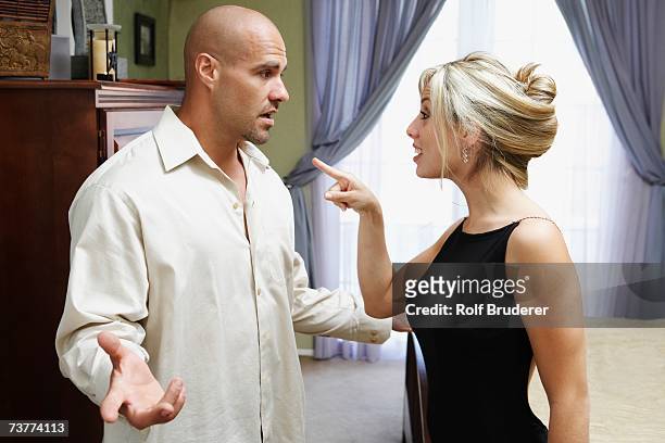 couple fighting in livingroom - couple pointing imagens e fotografias de stock