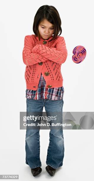 studio shot of pouting asian girl with lollipop - smart studio shot stockfoto's en -beelden