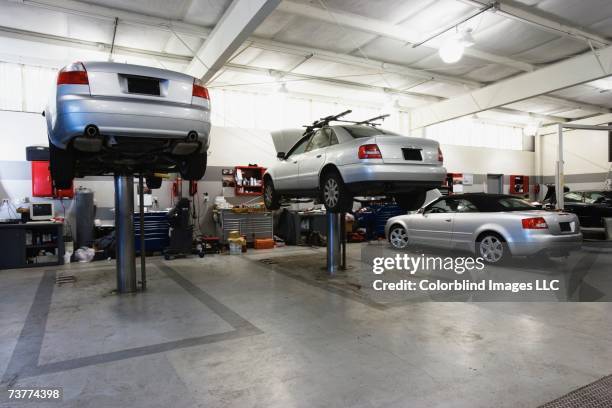 cars on hydraulic lifts at auto repair shop - car repair stock pictures, royalty-free photos & images