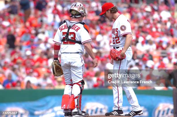 John Patterson of the Washington Nationals confers with catcher Brian Schneider during their game against the Florida Marlins during the Opening Day...