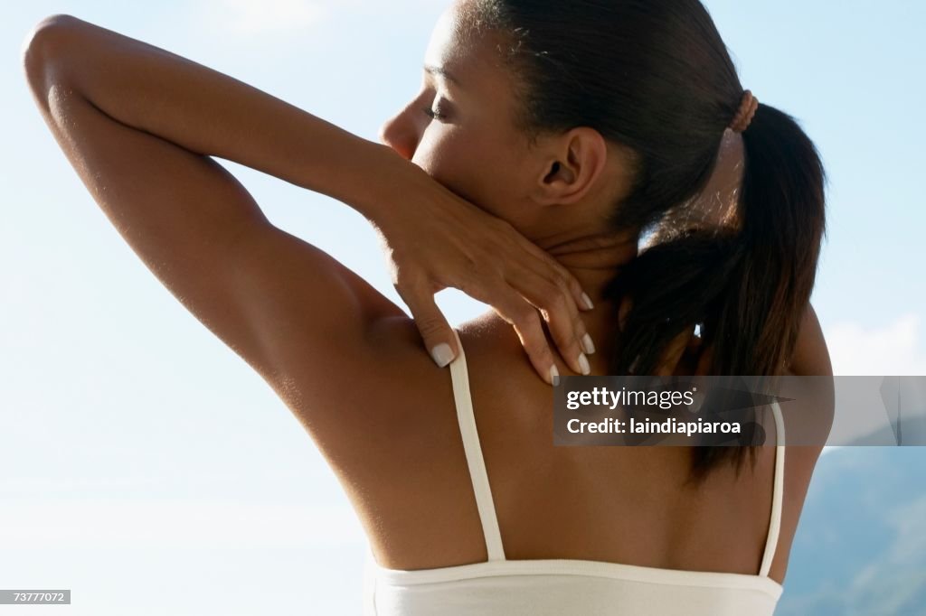 Rear view of African woman stretching outdoors