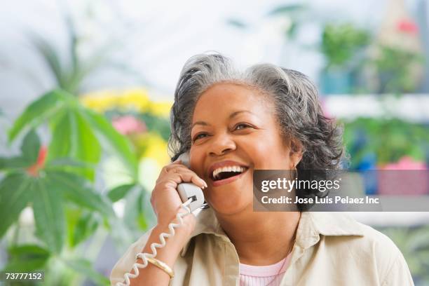 african woman using telephone - teléfono con cable fotografías e imágenes de stock