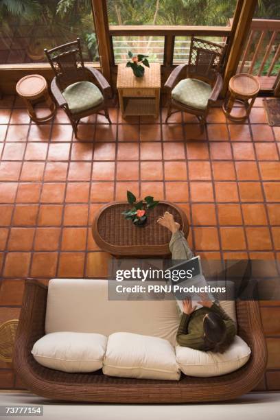 high angle view of woman using laptop on sofa - lech stock pictures, royalty-free photos & images