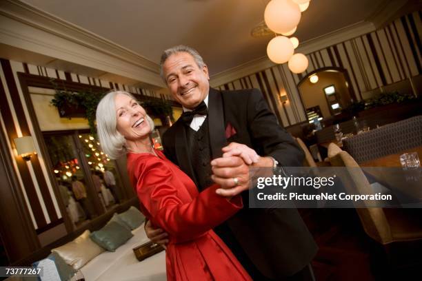 well dressed senior couple dancing in restaurant - tuxedo party stock pictures, royalty-free photos & images