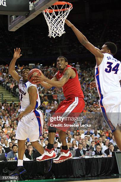 Mike Conley Jr. #1 of the Ohio State Buckeyes goes to the hoop against Marreese Speights and Taurean Green of the Florida Gators in the NCAA Men's...