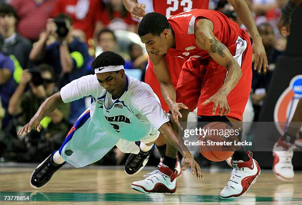 Corey Brewer of the Florida Gators fights for a loose ball against Mike Conley Jr. #1 of the Ohio State Buckeyes during the NCAA Men's Basketball...