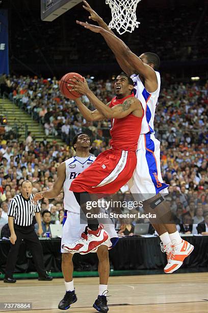 Mike Conley Jr. #1 of the Ohio State Buckeyes goes to the hoop against Marreese Speights and Taurean Green of the Florida Gators in the NCAA Men's...