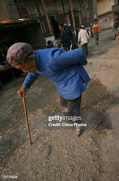 Year-old bound feet woman walks at Liuyi Village on April 2, 2007 in Tonghai County of Yunnan Province, China. Liuyi Village is known as the "Bound...