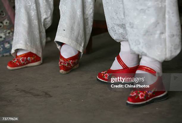 Members of the Bound Feet Women Dancing Team, dance on their "Three Cuns Golden Lotus" shoes at Liuyi Village on April 2, 2007 in Tonghai County of...