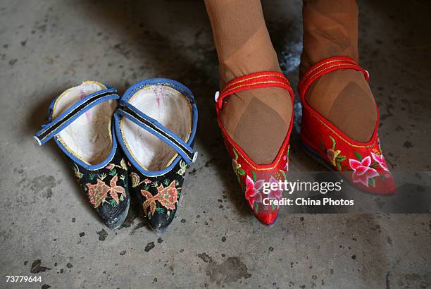 Year-old bound feet woman Fu Jifen, displays "Three Cuns Golden Lotus" shoes she made at Liuyi Village on April 2, 2007 in Tonghai County of Yunnan...
