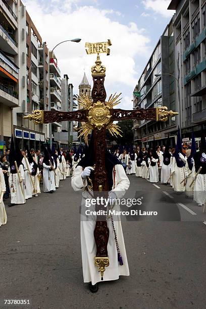 Member of "El Rocio" brotherhood carries a Cross as he walks during their procession on April 2, 2007 in Seville, Southern Spain. The Holy Week of...
