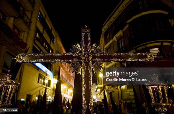 Member of "Las Aguas" brotherhood carries a Cross as he takes part in their procession on April 2, 2007 in Seville, Southern Spain. The Holy Week of...