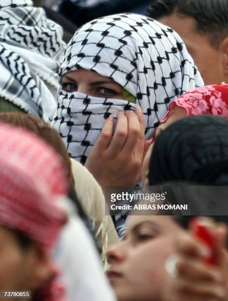 Palestinian student, supporter of the Fatah secular party, wears the trade mark black and white Kefiyeh worn by the late Palestinian leader Yasser...