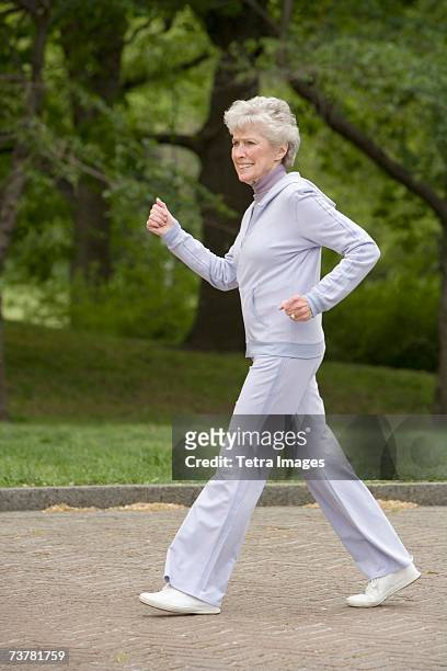 senior woman power walking - walking side by side stockfoto's en -beelden