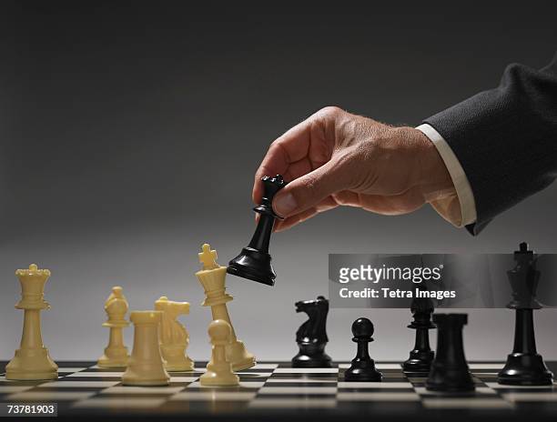 businessman moving chess piece - chess bildbanksfoton och bilder