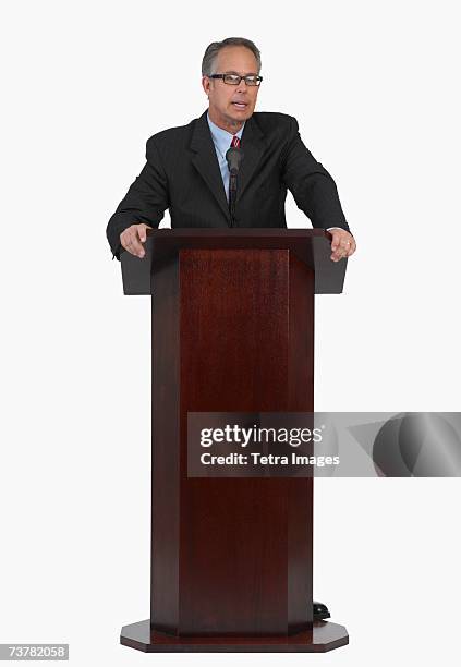 businessman speaking at podium - lectern stock-fotos und bilder