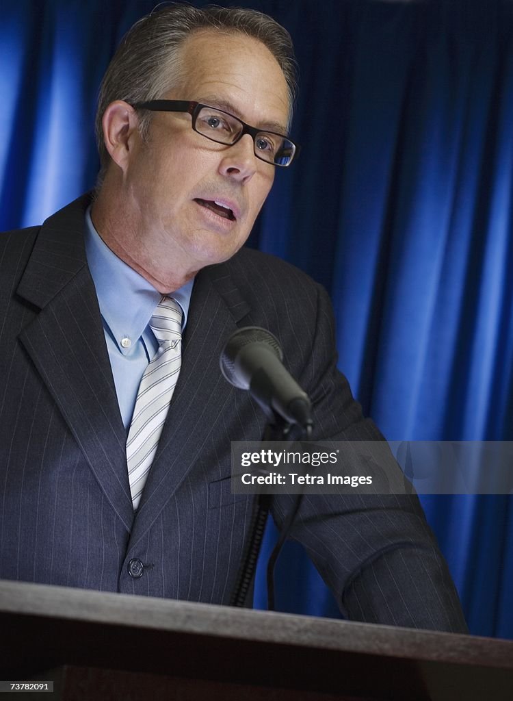 Close up of businessman speaking at podium