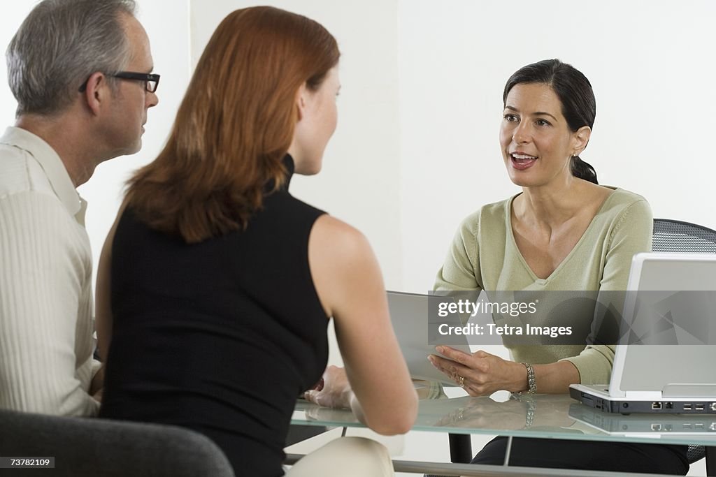 Businesswoman talking to clients at desk