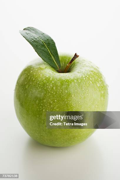 close up of apple with water droplets - manzana verde fotografías e imágenes de stock