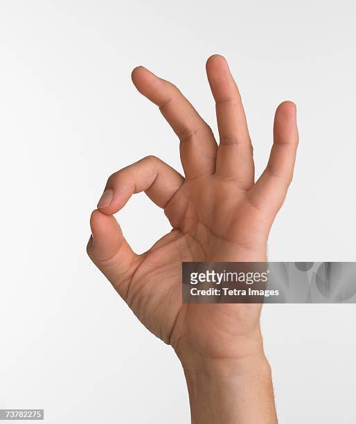 studio shot of hand giving the okay sign - inviting gesture stockfoto's en -beelden