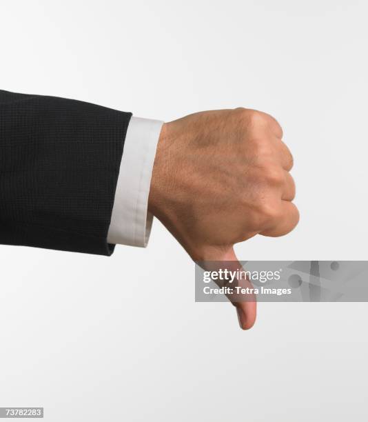 studio shot of businessman's hand giving thumbs down - polegar para baixo imagens e fotografias de stock