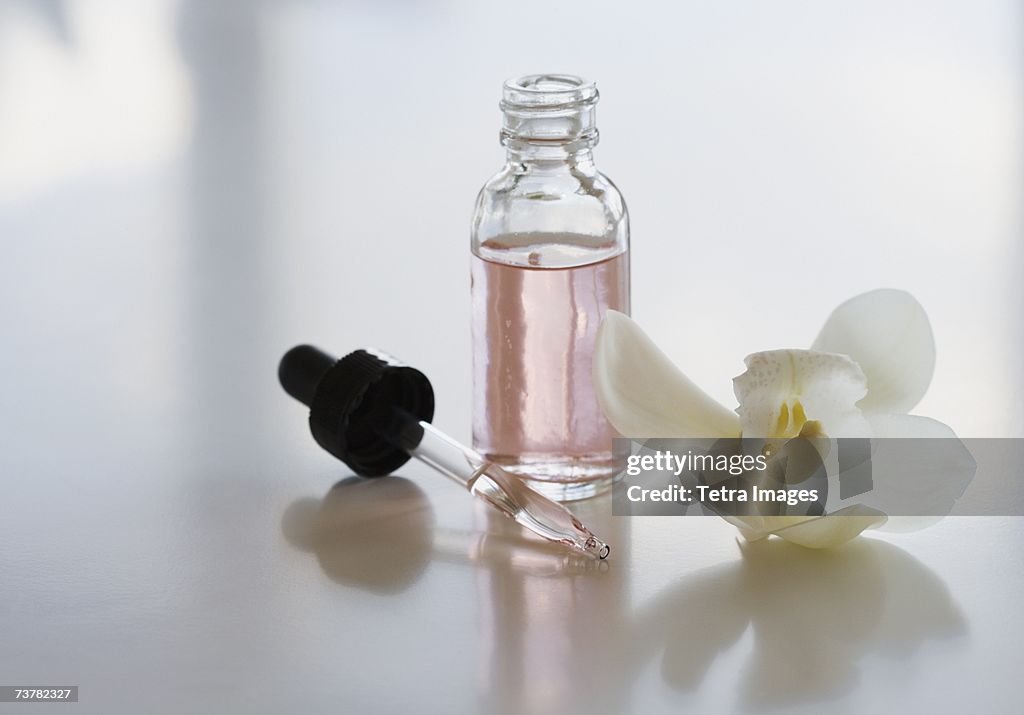 Close up of flower and bottle of oil