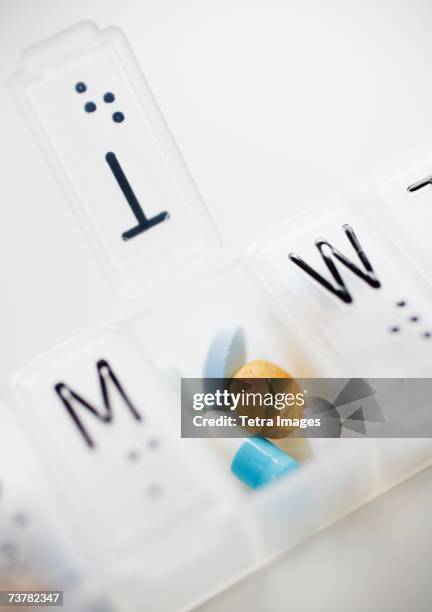 close up of pills in weekly organizer - weekly pill box stock pictures, royalty-free photos & images