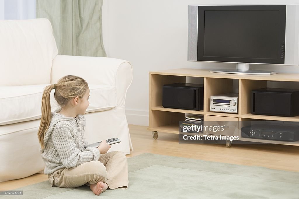 Girl sitting on floor watching television