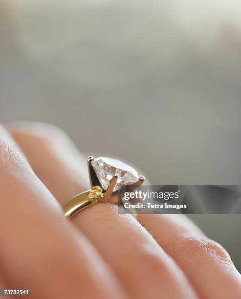 close up of diamond engagement ring - finger studio close up stock-fotos und bilder