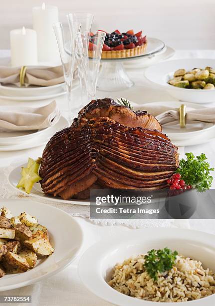 spiral ham and side dishes on set table - spiral ham stock pictures, royalty-free photos & images