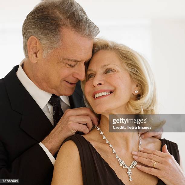 senior man giving diamond necklace to wife - diamond necklace stock pictures, royalty-free photos & images